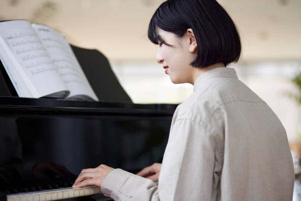 istock Young Japanese women playing the piano 1457538562