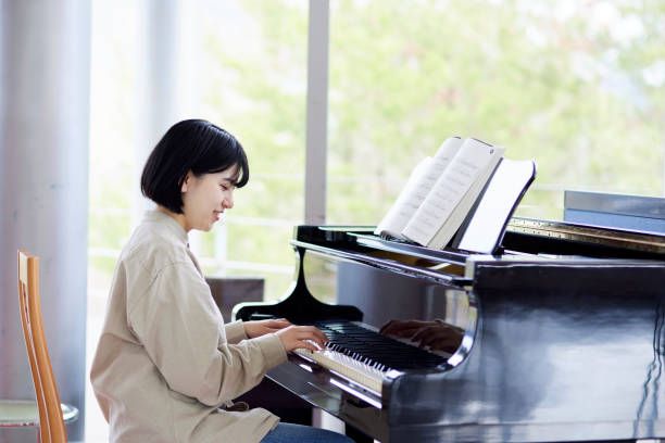 istock Young Japanese women playing the piano 1457538572