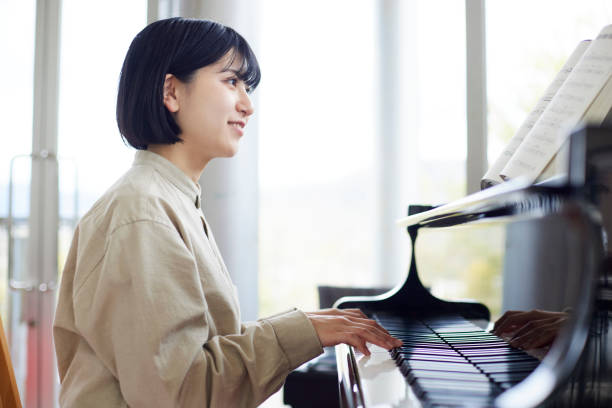istock Young Japanese women playing the piano 1457538584