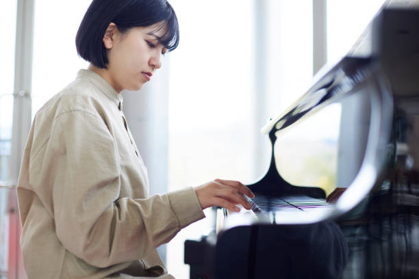 istock Young Japanese women playing the piano 1457538586