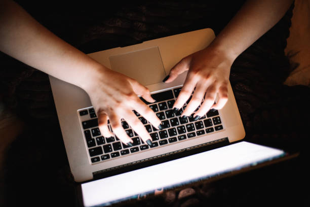 istock Cropped image of female hands typing on laptop computer at home at night 1457538588