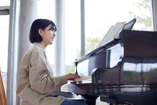istock Young Japanese women playing the piano 1457538599