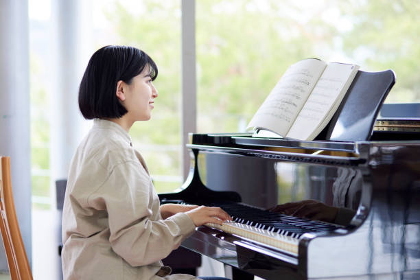 istock Young Japanese women playing the piano 1457538601