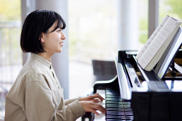 istock Young Japanese women playing the piano 1457538605