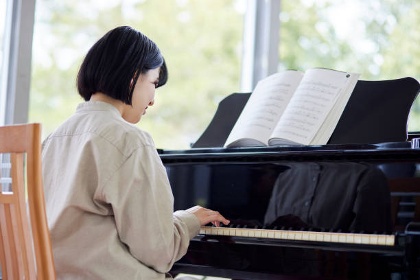 istock Young Japanese women playing the piano 1457538641