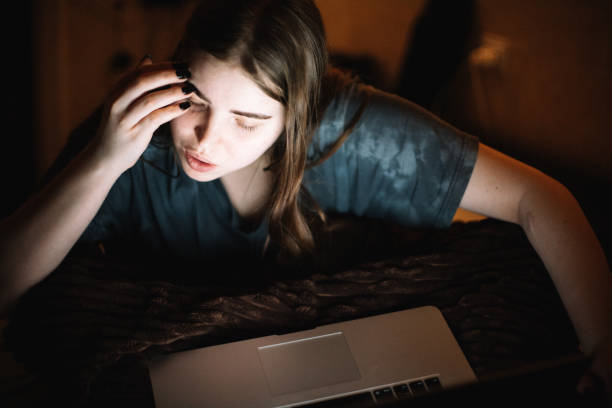 istock Young woman using laptop computer having video call at home at night 1457538658