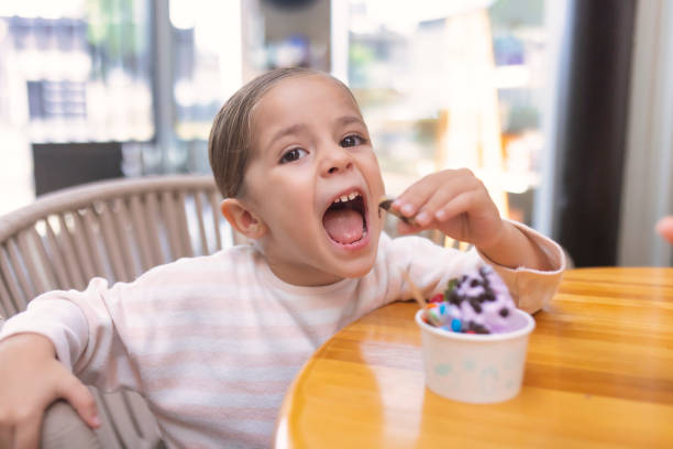 istock Girl eating biscuit with ice cream 1457540403