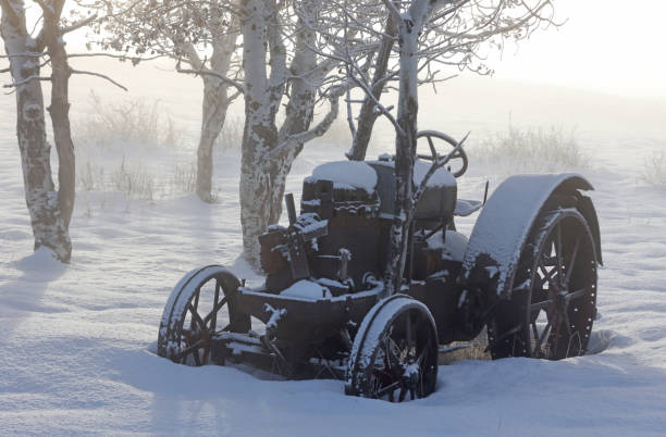 An old tractor on an abandoned farm in winter.