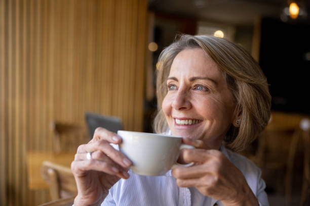 istock Happy senior woman drinking coffee at a cafe 1457546919