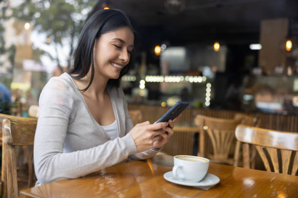 istock Woman texting on her cell phone at a cafe while drinking coffee 1457547098