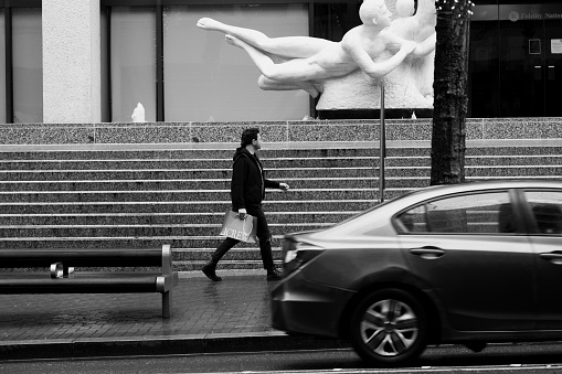 Black and white images of people walking on the sidewalk of downtown Portland in the rain.