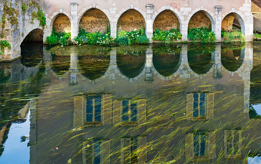 A reflection of an ancient building in the Eure River in Chartres, France.