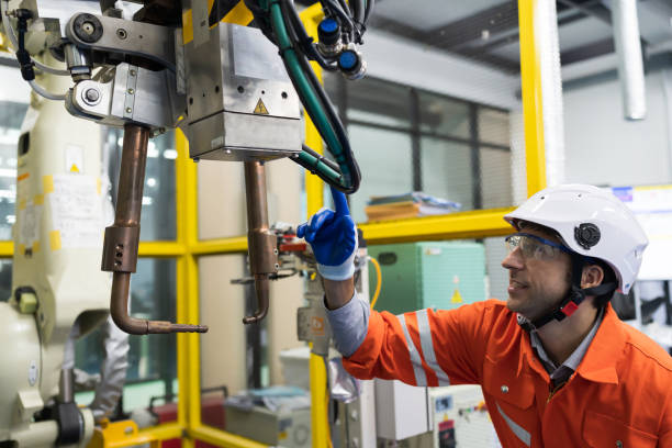 istock Male engineer repair or maintenance automatic robot arm system in the manufacturing automation and robotics factory 1457556833
