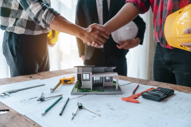 Shaking hands, Blueprints architects and building engineers talking meeting and planning will chronicle the design and technical aspects of a new house construction, renovation remodeling. estrechando la mano, los arquitectos de blueprints y los ingenieros de construcción que hablarán sobre la reunión y la planificación narrarán el diseño y los aspectos técnicos de la construcción de una nueva casa, la remodelación de la renovación