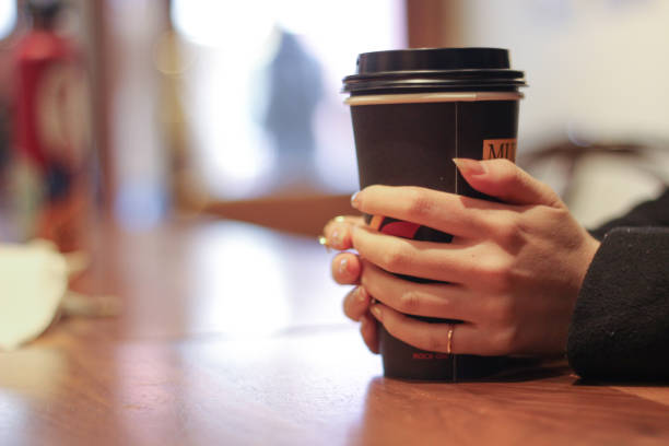 istock tea holding flower hands candle coffee shop cozy 1457562045