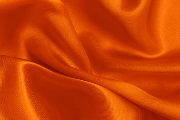 Orange fabric cloth texture for background and design art work, beautiful crumpled pattern of silk or linen.