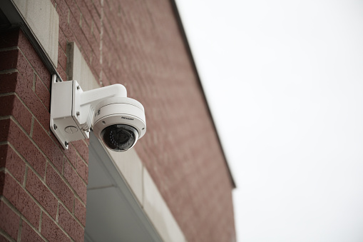 Close-up of surveillance camera in underground parking space.