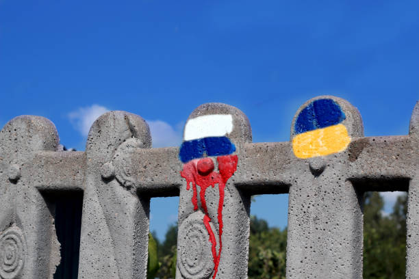 Painting fence with Russia and Ukraine flag's color. Stop War in the Ukraine. stock photo