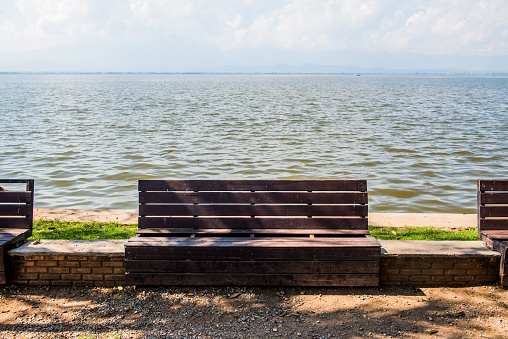 Wooden bench beside Phayao lake, Thailand.