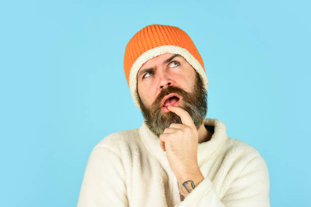 istock Funky thinking bearded man. mature man posing with funny outfit. man beard in winter hat. portrait of trendy guy wearing hat. Male winter style. Modern winter knitted beanie hat 1457577647