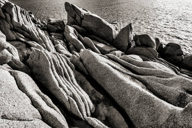 Eroded coastline of Corsica in black and white littoral Corse en noir et blanc avec ses rochers en granite érodés image en noir et blanc stock pictures, royalty-free photos & images