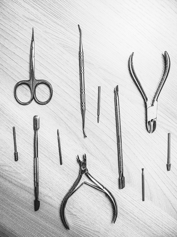 manicure tools lie on the tablenail ,nail nippers, nail scissors, nailfile,nail curette top view, black and white photo,manicure at home,beauty salon,copy space