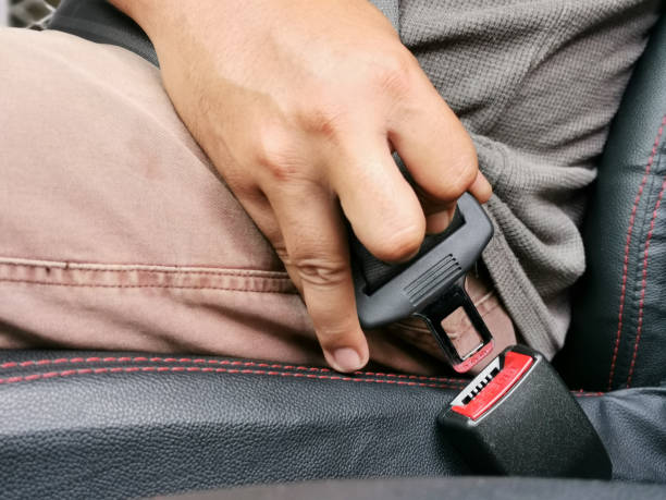 istock Close up image man hand fastens car seat belt. 1457585471