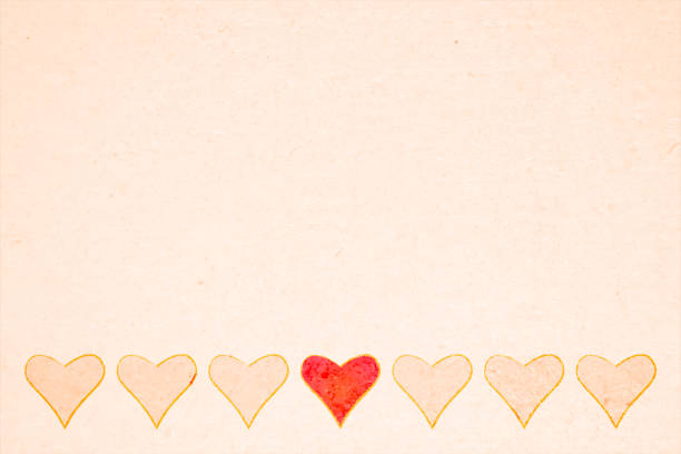 istock Soft Valentine Day or love theme light beige backgrounds with a bottom border design of a row of hearts pattern and the middle odd one out unique different from the rest of the crowd red heart that stands out and the rest plain with empty copy space 1457587177