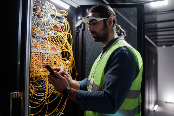 бородатый сетевой техник ремонтирует серверы в дата-центре - network server data center installing стоковые фото и изображения