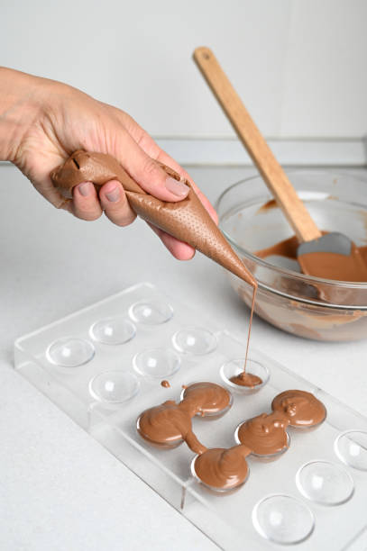 istock Filling a chocolate mold with a piping bag. Making chocolates concept 1457589554