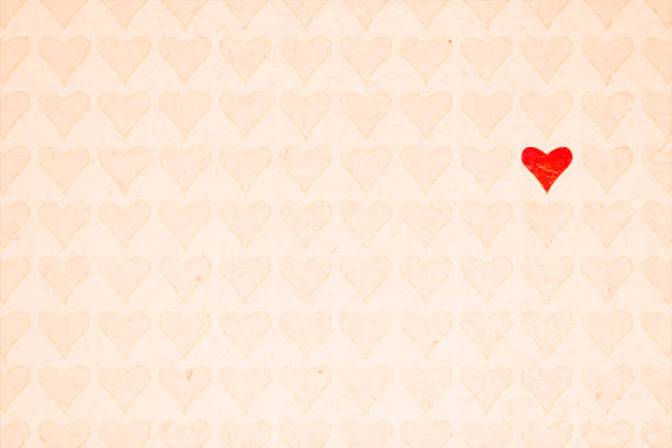 istock Soft Valentine Day or love theme light beige backgrounds with a design of all over hearts pattern and one odd one out unique different from the rest of the crowd red heart that stands out 1457589632