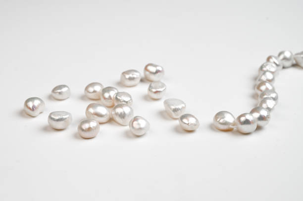 istock Natural freshwater round baroque pearl beads on white background. Top view 1457590656