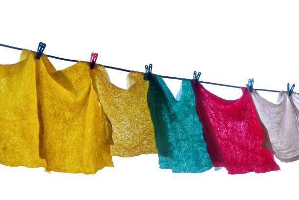 In Selective focus A group of multiple color rags hanging on a wire line and drying in outdoor,on white isolated background