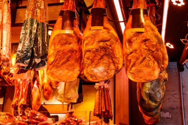istock Jamon serrano ham legs hanging in a traditional spanish market 1457592717