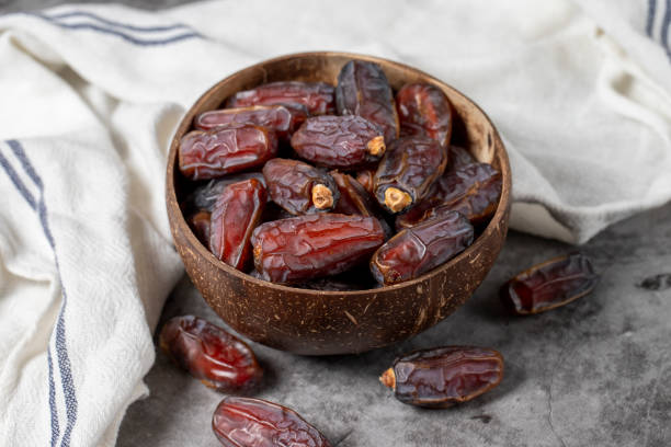 Date fruit on a dark background. Organic medjoul dates in bowl. Ramadan food. Close-up stock photo