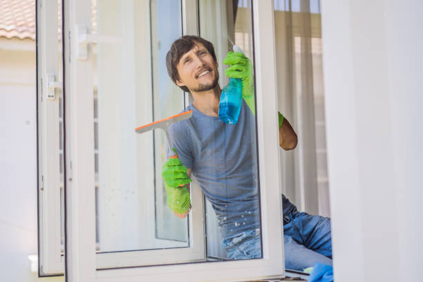 istock A young man cleaning the window with a window cleaner 1457608418