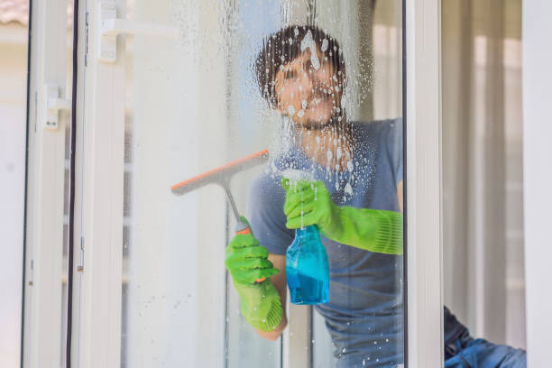 istock A young man cleaning the window with a window cleaner 1457608424