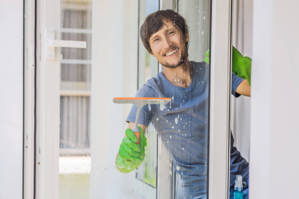 istock A young man cleaning the window with a window cleaner 1457608427