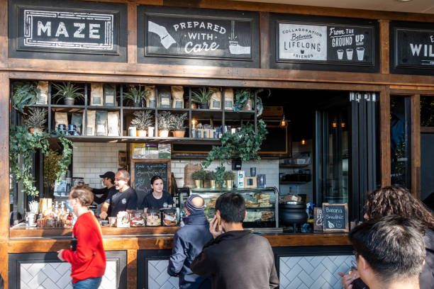 Sydney, Australia - May 31, 2022: Customers queue in line to receive their coffee orders from the Maze Cafe in the University of New South Wales (UNSW). Cafe also offers many other food items.