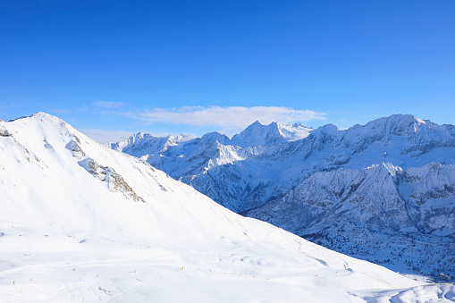 alpine landscape with peaks covered by snow and clouds