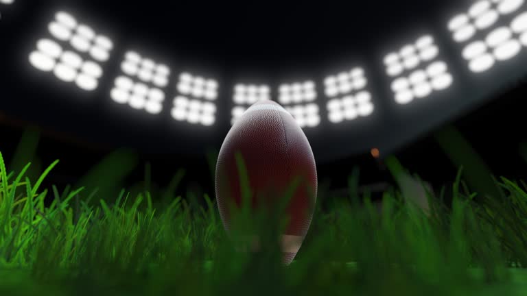 Rugby ball in football stadium with floodlights loopable super bowl concept