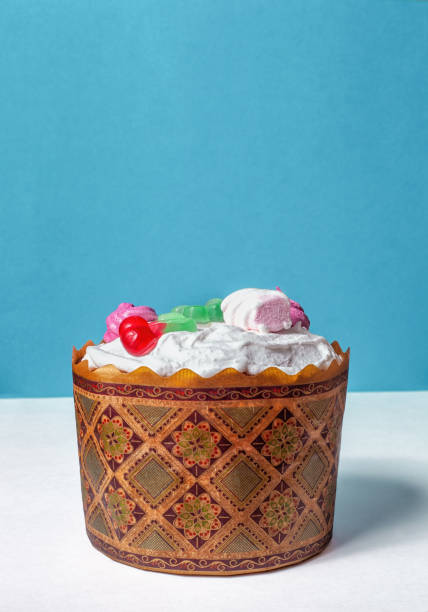 istock Homemade Kulich. Baked Easter cake decorated with white icing, marshmallows and candies 1457613866