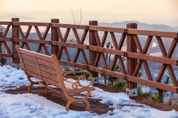 Empty wooden bench on a snowy mountain terrace in public park of Busan, South Korea