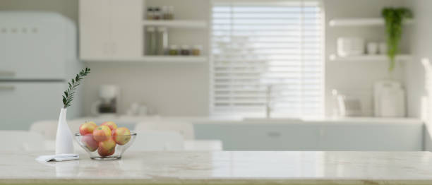 istock Empty space on kitchen tabletop over blurred background of minimal white kitchen room. 1457616961