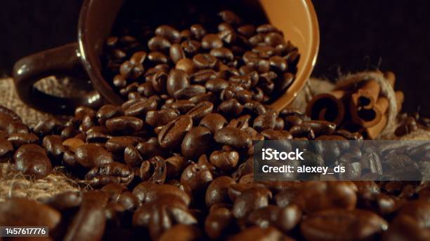 Coffee Grains Pouring From The Cup And Cinnamon Sticks Stock Photo - Download Image Now