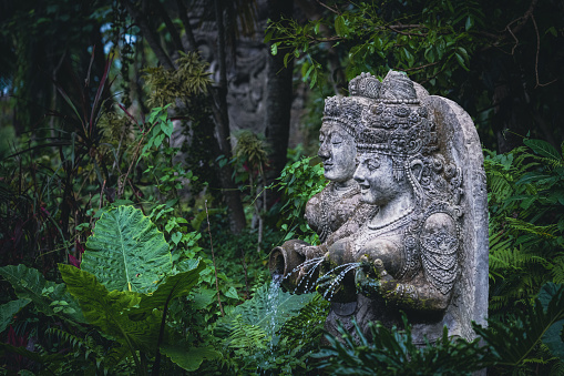 Traditional demon sculptures made of stone in the jungle of the Bali island, Indonesia. Seen at the Monkey Forest in Ubud.