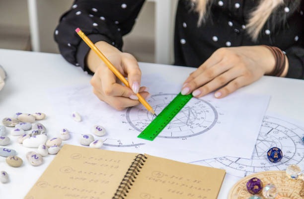 Woman astrologer draws a natal chart. Selective focus. Woman astrologer draws a natal chart. Selective focus. People. zululand stock pictures, royalty-free photos & images