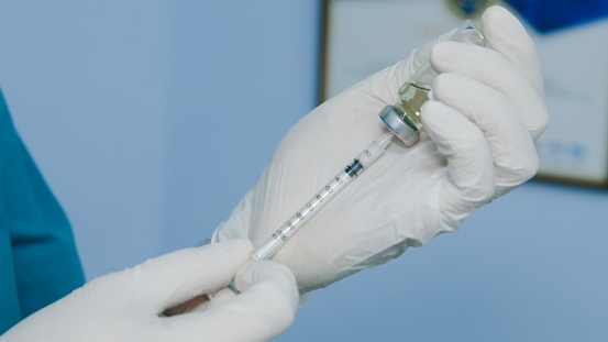 Nurse fills syringe with the medicine for injection
