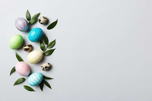Colorful Easter eggs with spring flower leaf isolated over white background. Colored Egg Holiday border.