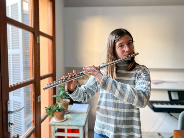 jeune adolescente jouant de la flûte traversière - flûte traversière photos et images de collection